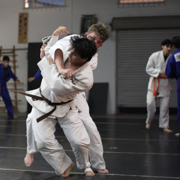 Two athletes practicing judo in white gi.