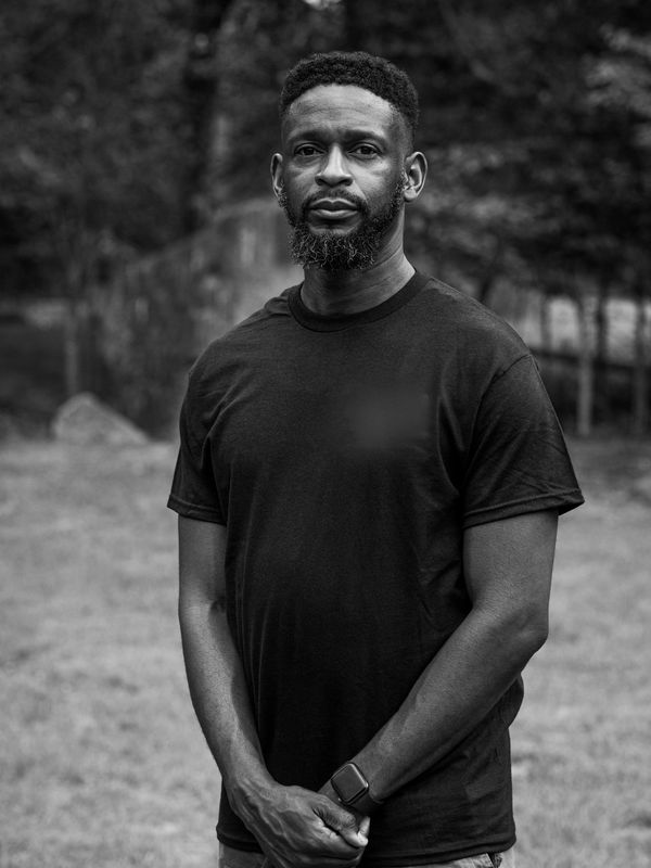 Black and white portrait of a man in a plain t-shirt.