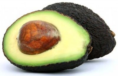 A ripe avocado, one half shows the seed and green flesh.