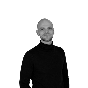 Smiling man in a black turtleneck against a plain background.