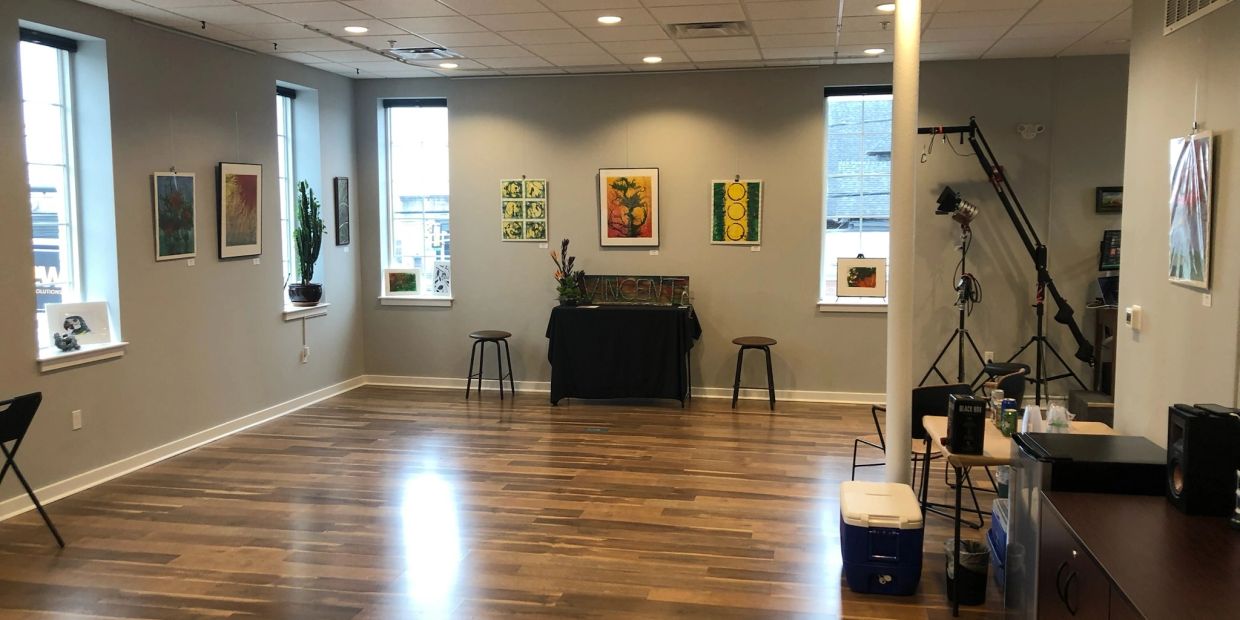 Art gallery with paintings and wooden floor.
