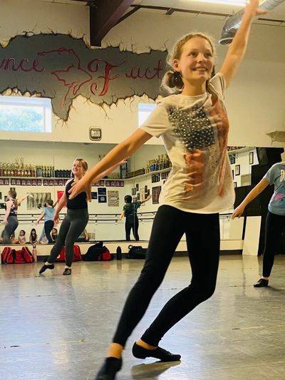 Smiling teen dancer showcasing technique and confidence in dance class