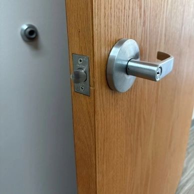 Modern silver door handle on wooden door with a lock mechanism.