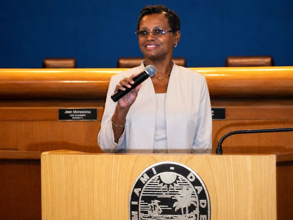 Woman speaking confidently at a Miami-Dade podium.