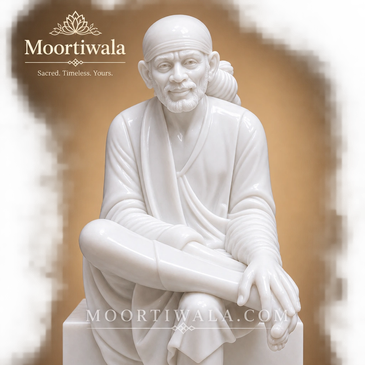 Marble statue of Sai Baba sitting cross-legged.