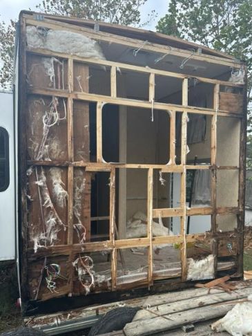 Exposed wooden frame of a damaged RV wall.