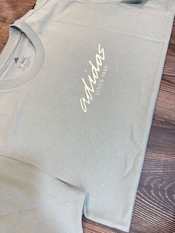 Light blue Adidas T-shirt with white text.