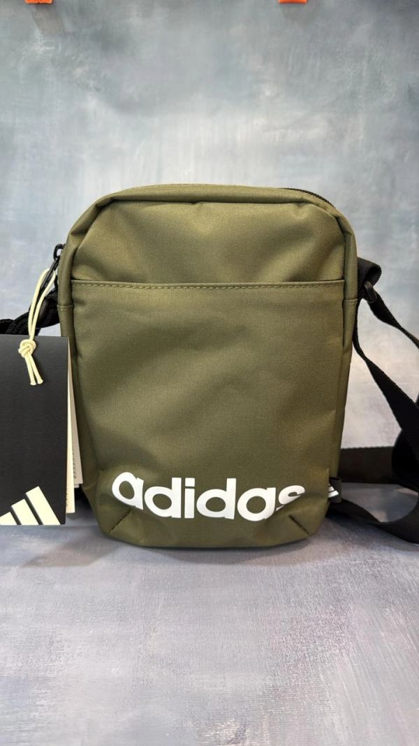 Green Adidas crossbody bag with white logo.