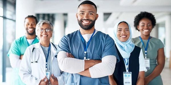Smiling diverse medical team standing confidently in a hospital.