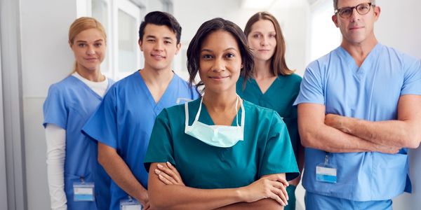Diverse medical team standing confidently in hospital corridor.