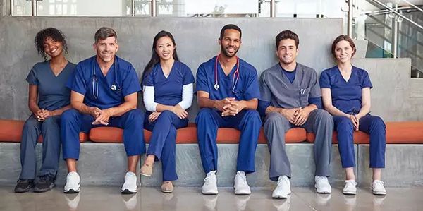 A diverse group of medical professionals sitting together, smiling.