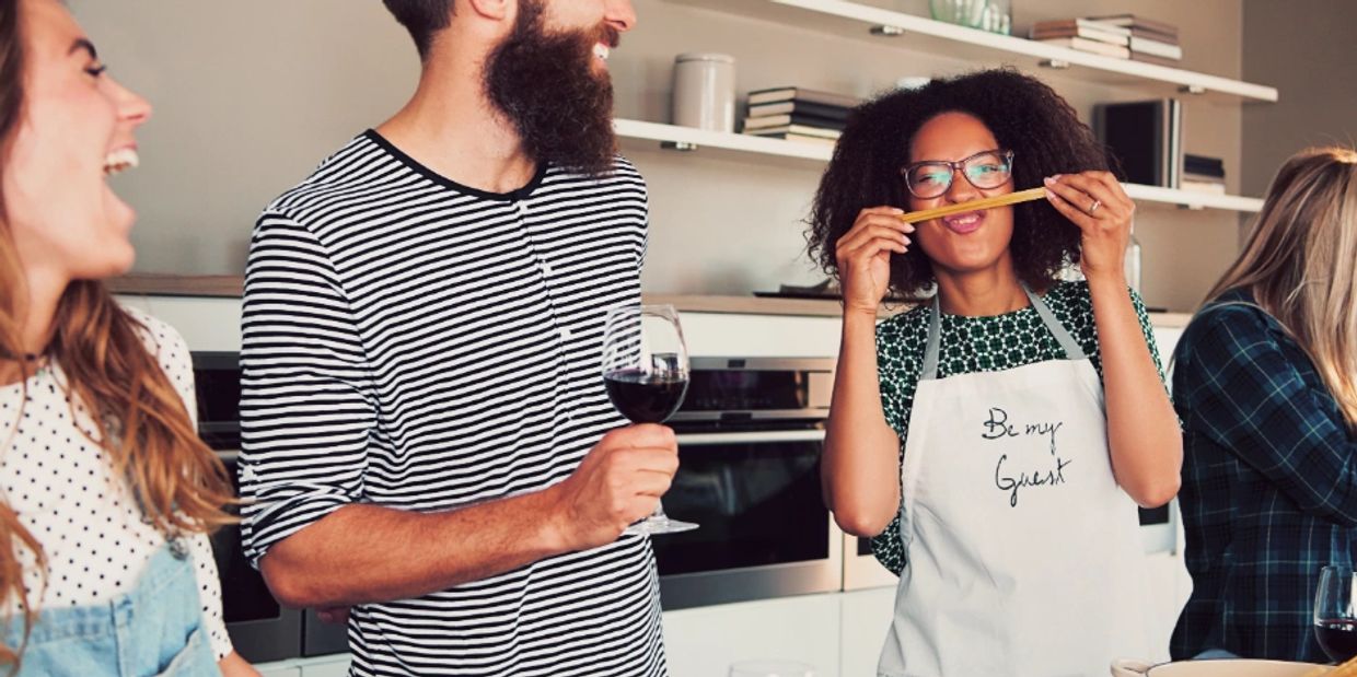 Friends laughing and enjoying time in the kitchen.