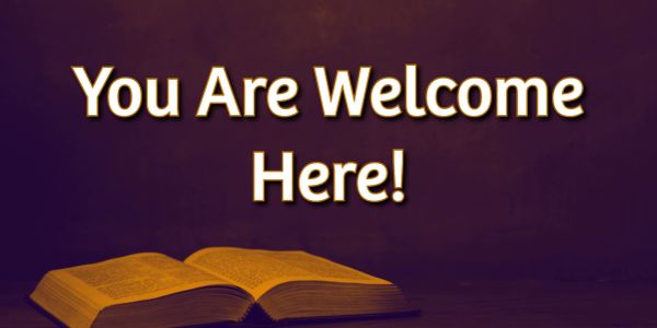 Sign saying 'You Are Welcome Here!' with an open book.