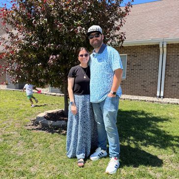 Couple posing outdoors on a sunny day.