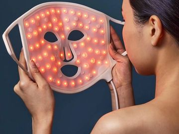 woman holding a NuShape Red Light therapy mask