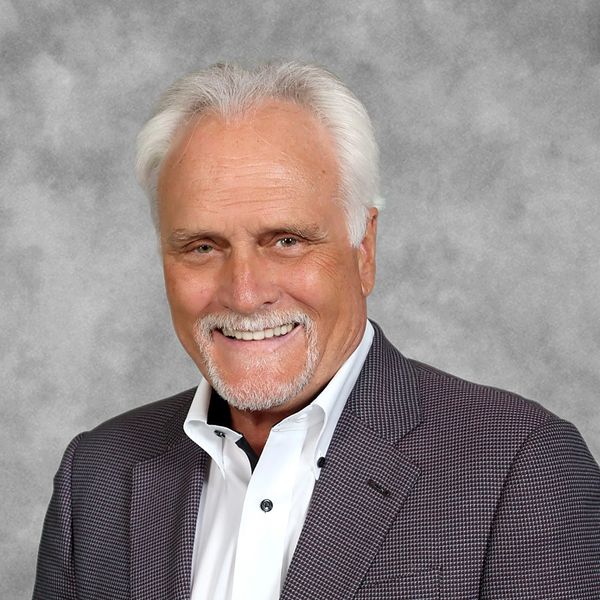 Smiling elderly man in suit.