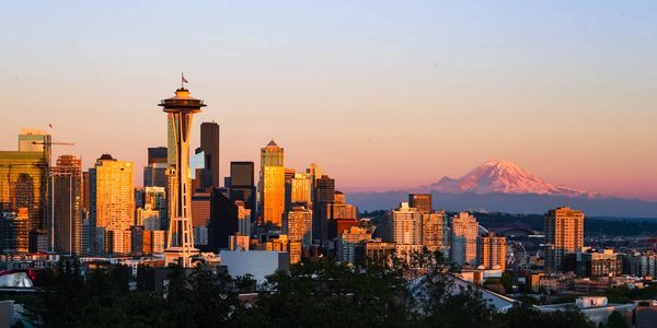 Seattle skyline with Space Needle and Mount Rainier at sunset.