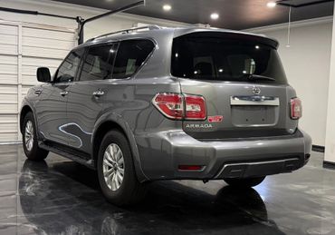 Gray Nissan Armada SUV parked indoors on a shiny floor.