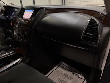 Interior view of a car dashboard with a touchscreen and wooden trim.