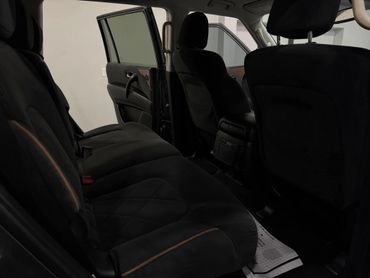 Interior view of a car showing black fabric seats and an open rear door.