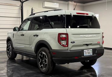 White Ford Bronco SUV parked indoors in a garage.