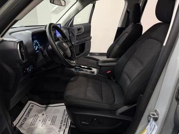Clean and modern car interior with black fabric seats and digital dashboard.