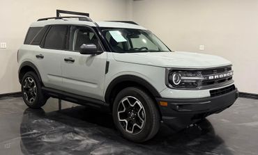 A white Ford Bronco SUV parked indoors on a polished floor.