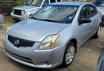 Silver Nissan sedan parked on driveway.