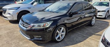 Black sedan parked among other cars.