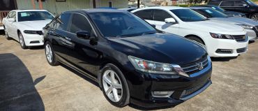 Black sedan parked with white cars around.