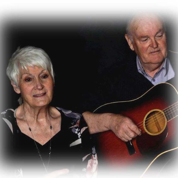  Portrait of mature male and female singing favorite song while playing on guitar 