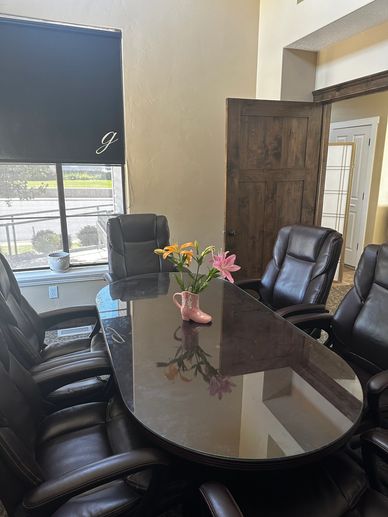 A sleek conference room with leather chairs and a floral centerpiece.