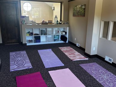 Yoga studio with six colorful mats neatly arranged on the floor.