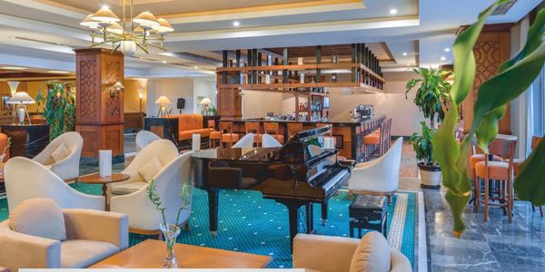 Konforlu koltuklar ve piyano bulunan otel lobi alanı.