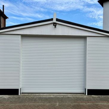 Closed white garage door under a blue sky.
