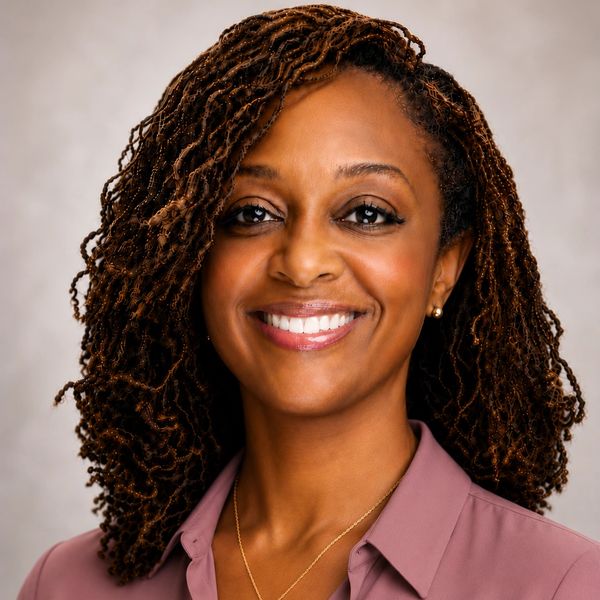 Woman with curly hair smiling.