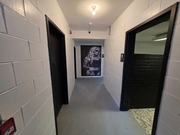 Dimly lit hallway with a black and white mural at the end.