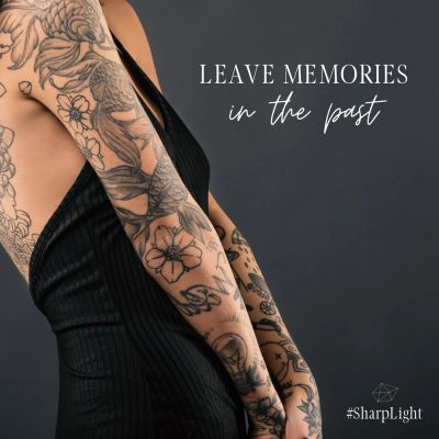 Tattooed woman in black dress with inspirational quote.