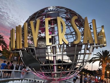 Iconic Universal globe at sunset with visitors around.