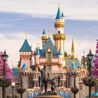 Disney castle with statue of Walt Disney and Mickey Mouse.
