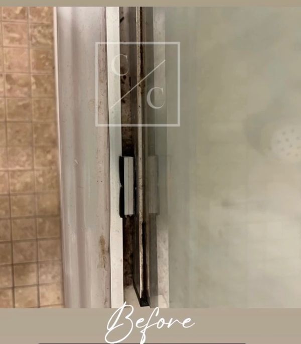 Close-up of dirty shower door track needing cleaning.