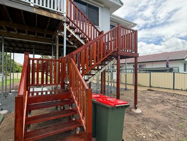 Newly stained wooden outdoor stairs attached to a house.
