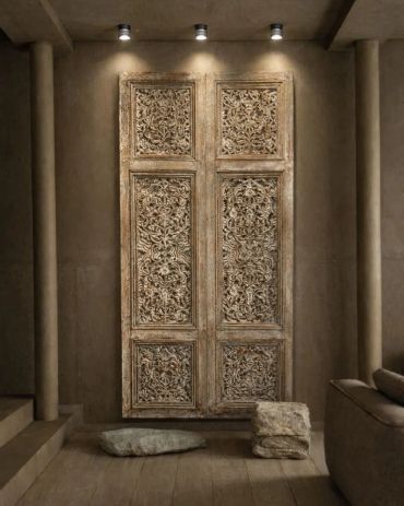 Intricately carved wooden panels displayed in a minimalist, earthy-toned room.