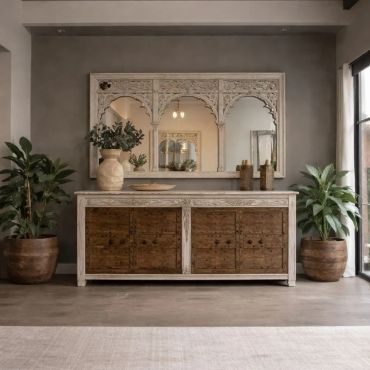 Rustic sideboard with large decorative mirror and potted plants in a cozy room.