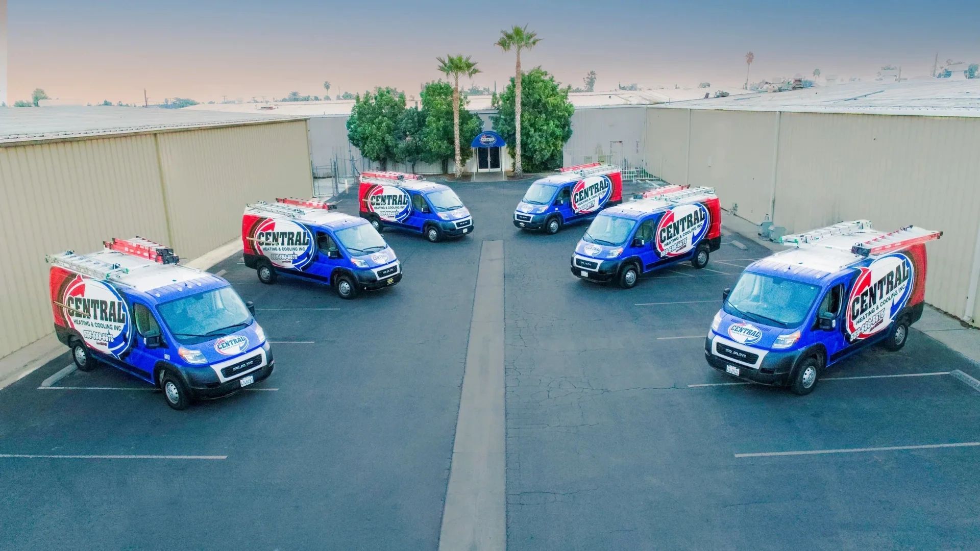 Fleet of six Central Heating & Cooling vans parked in a lot.