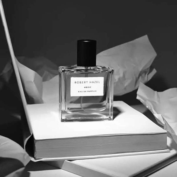 Perfume bottle on white book with crumpled paper.