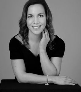 Smiling woman in black and white portrait.