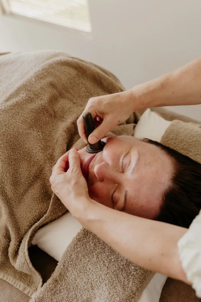 Person receiving a facial massage with a tool.