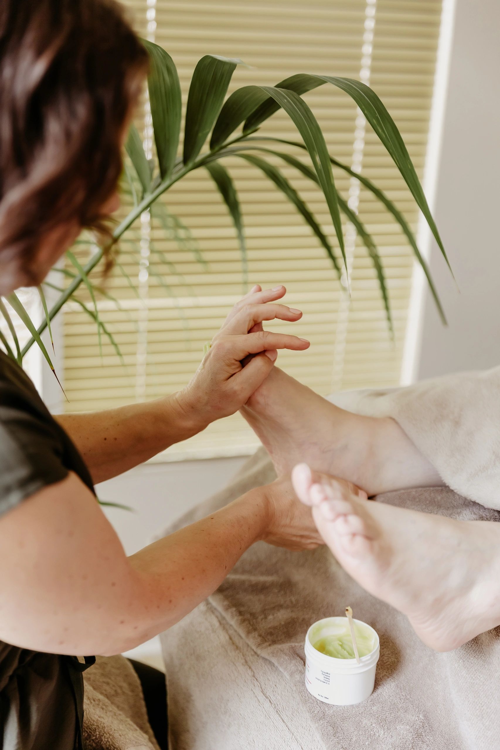 Person giving a foot massage with lotion.