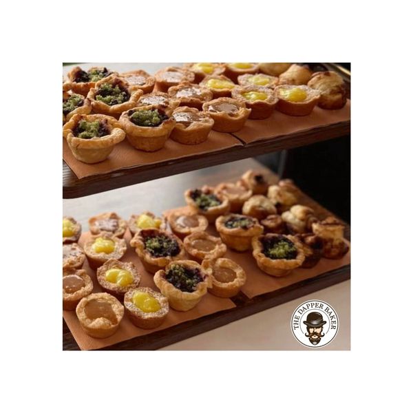 Assorted mini tarts on two wooden trays.